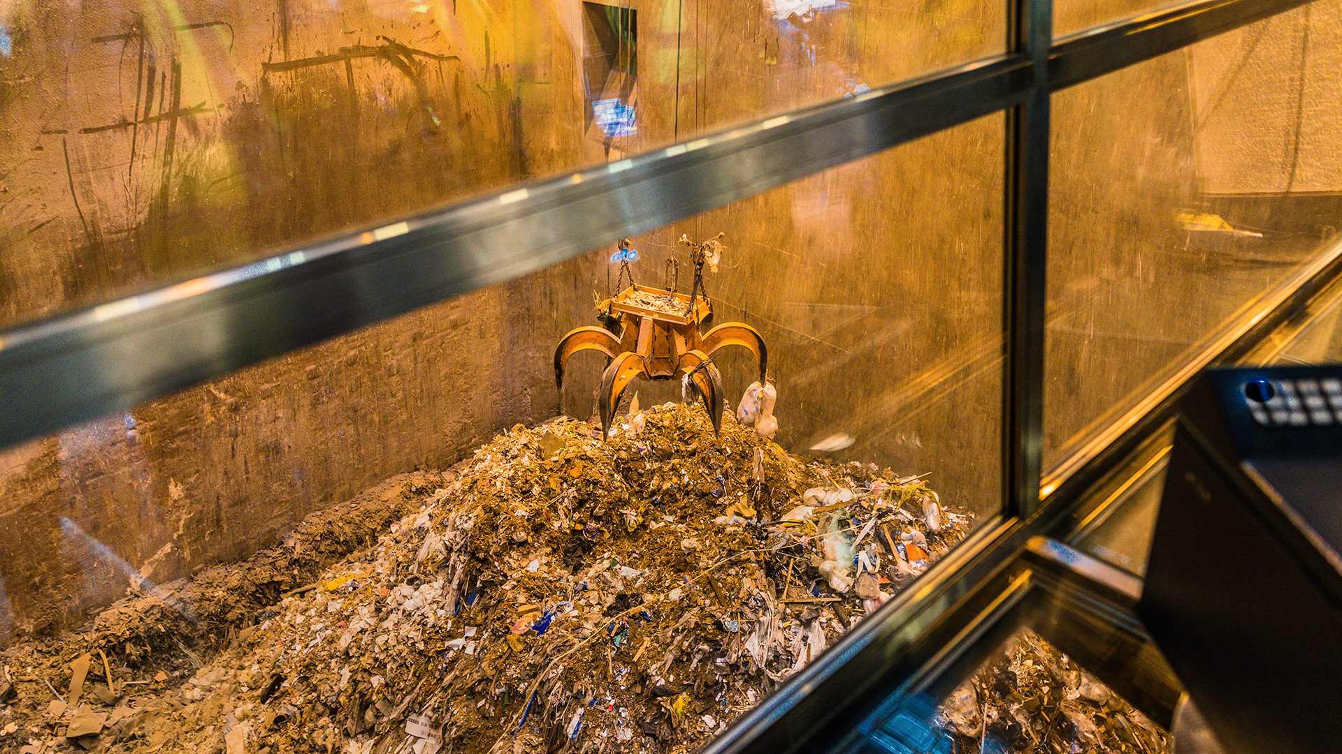 A grapple lifting trash to make waste-to-energy